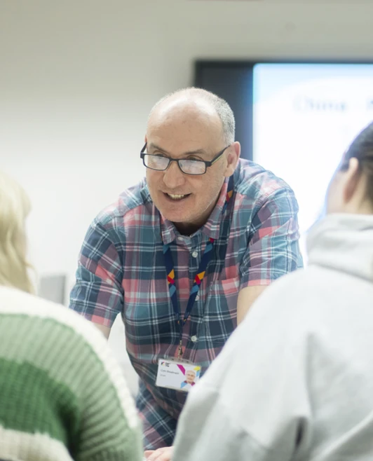 Smiling lecturer interacts closely with two students during a class at Glasgow Kelvin College. Smiling lecturer interacts closely with two students during a class at Glasgow Kelvin College.